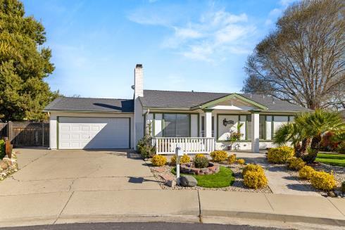 ranch-style house with a porch, a garage, fence, concrete driveway, and a chimney