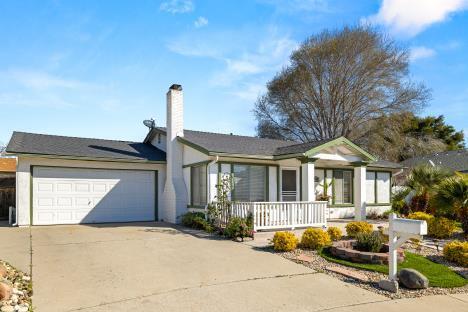 single story home featuring covered porch, concrete driveway, a chimney, and an attached garage