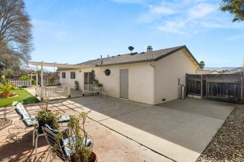 rear view of house featuring a patio, fence, and stucco siding