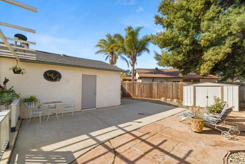 view of patio with an outbuilding, a shed, and fence