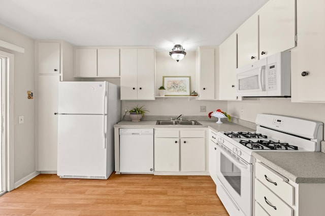 kitchen with white appliances, light wood-type flooring, a sink, and white cabinets