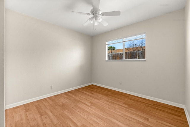 empty room with light wood-type flooring, a ceiling fan, and baseboards