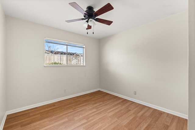 unfurnished room with light wood finished floors, baseboards, and a ceiling fan