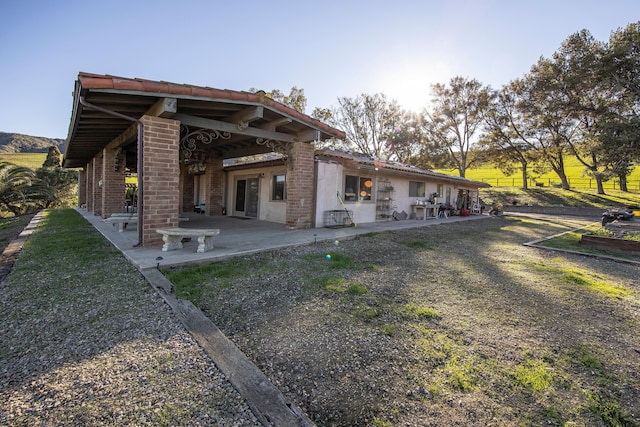 back of property with a patio, brick siding, and fence