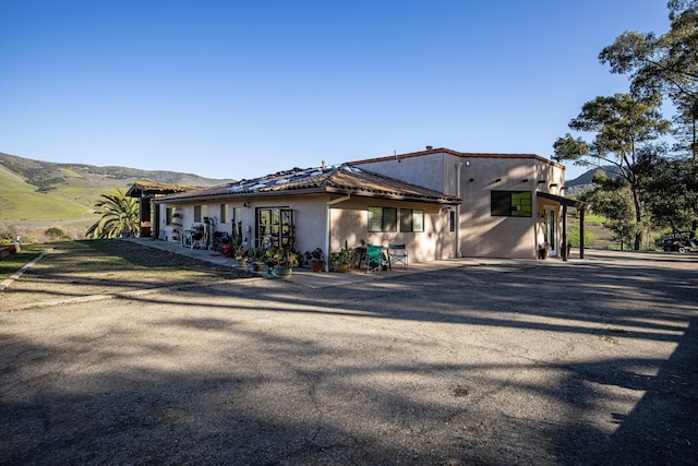 view of front facade featuring a mountain view and stucco siding