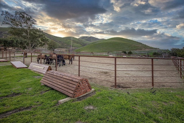 exterior space featuring an enclosed area, a rural view, an exterior structure, and a mountain view