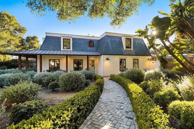 view of front of property with metal roof, mansard roof, a standing seam roof, and a porch