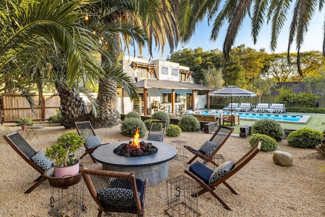 exterior space with a fenced in pool, an outdoor fire pit, fence, and a patio