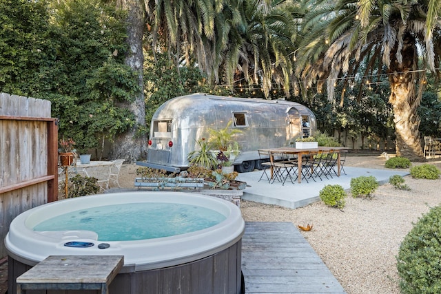 view of patio / terrace with outdoor dining area, fence, and a hot tub