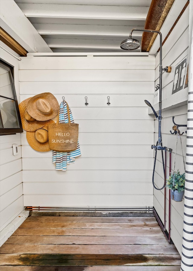 mudroom with wood walls and wood finished floors