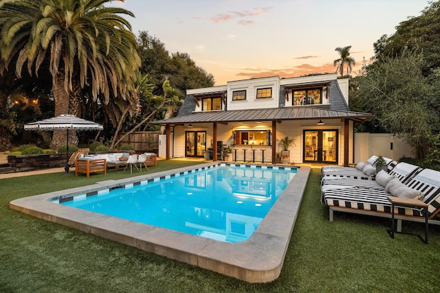 view of pool featuring fence, an outdoor living space, a fenced in pool, and french doors