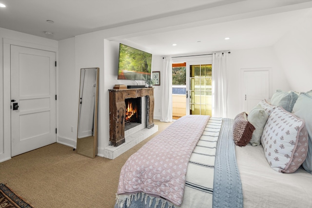 bedroom with recessed lighting, light colored carpet, access to exterior, baseboards, and a lit fireplace