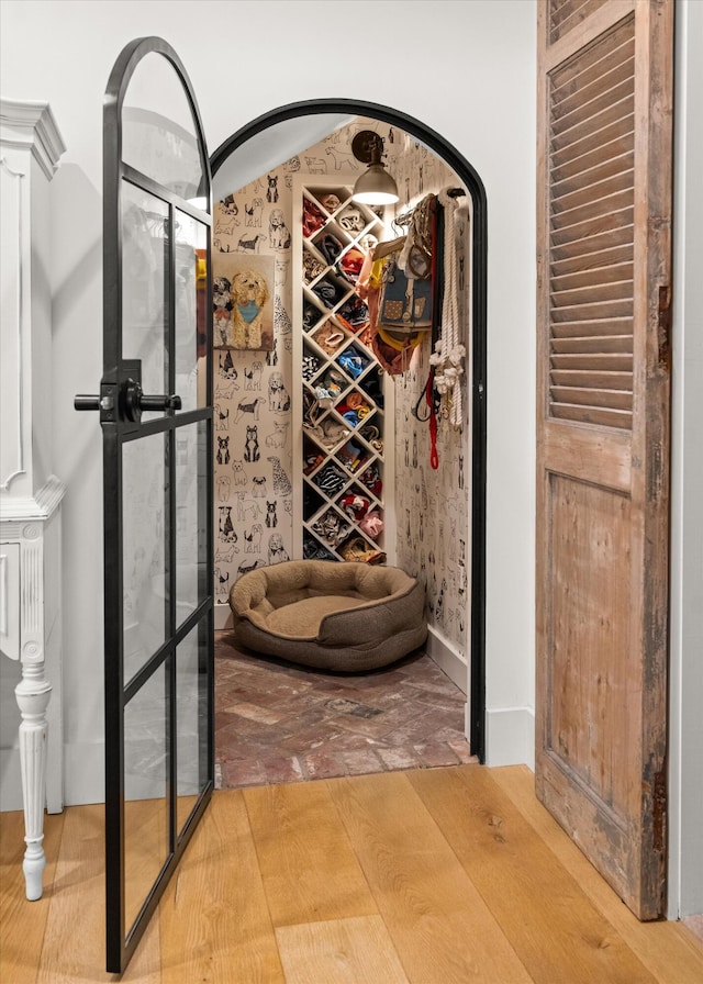 wine room featuring arched walkways and wood finished floors