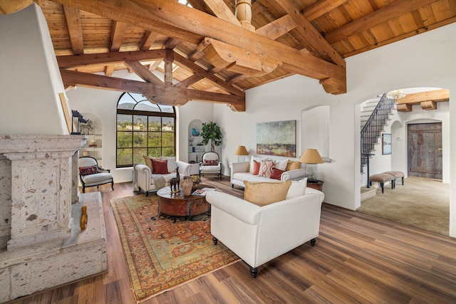 living room with arched walkways, wooden ceiling, wood finished floors, stairs, and beam ceiling