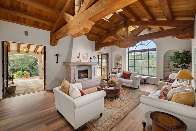 living room with wood ceiling, wood finished floors, high vaulted ceiling, beam ceiling, and a high end fireplace