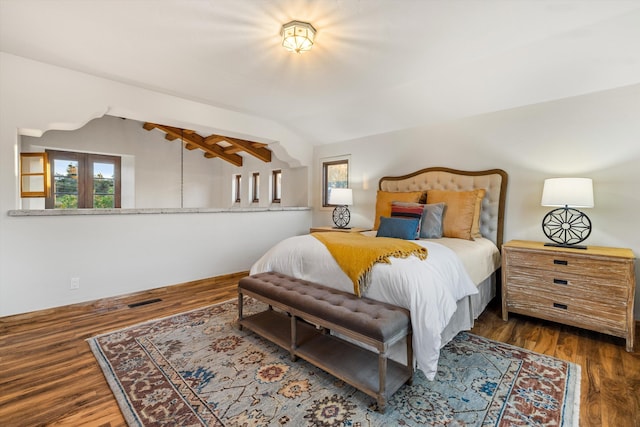 bedroom featuring lofted ceiling, visible vents, and wood finished floors