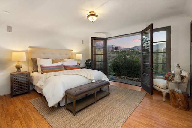 bedroom featuring access to outside, french doors, and wood finished floors