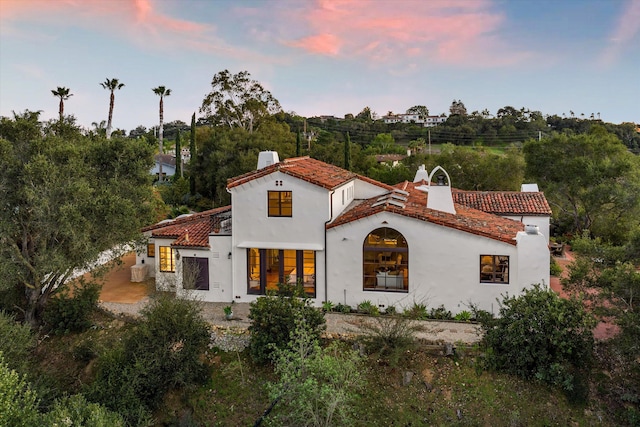 view of front of house featuring a chimney and stucco siding