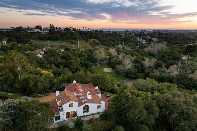 aerial view at dusk with a wooded view