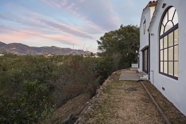 yard at dusk with french doors and a mountain view