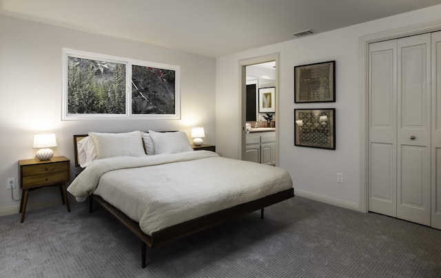 bedroom with dark colored carpet, a closet, visible vents, connected bathroom, and baseboards