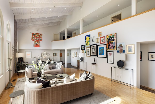 living area featuring wood ceiling, high vaulted ceiling, light wood-type flooring, and beam ceiling