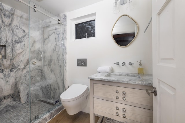 bathroom with toilet, wood finished floors, a marble finish shower, and vanity