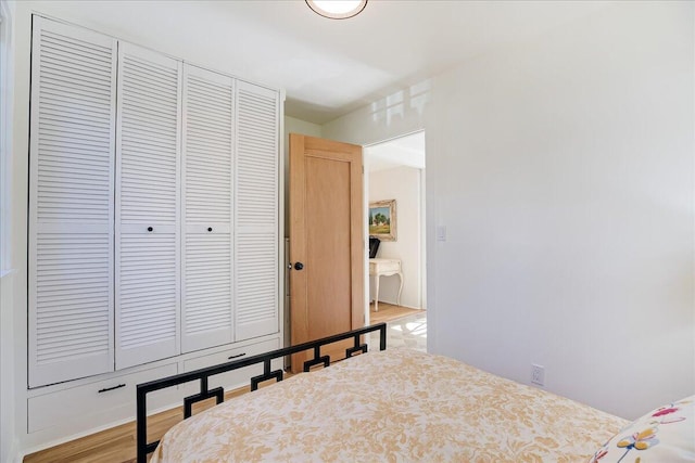 bedroom featuring light wood finished floors and a closet