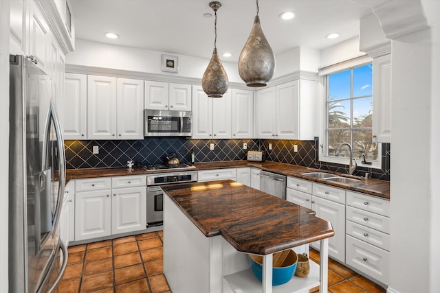 kitchen with stainless steel appliances, white cabinets, a center island, open shelves, and dark countertops