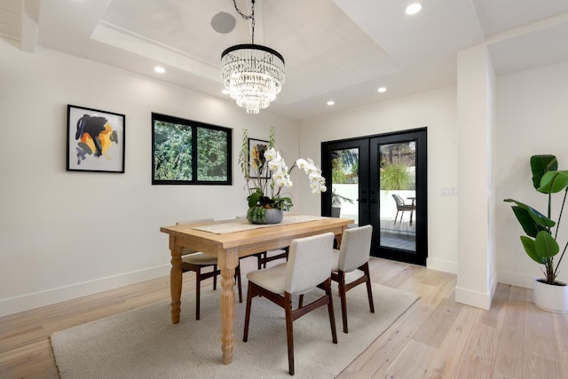 dining room featuring recessed lighting, french doors, light wood-type flooring, and a raised ceiling