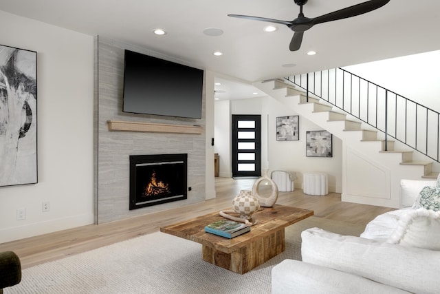 living area with ceiling fan, stairs, recessed lighting, a fireplace, and wood finished floors