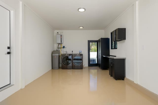 interior space featuring ornamental molding, washing machine and dryer, water heater, light countertops, and dark cabinets