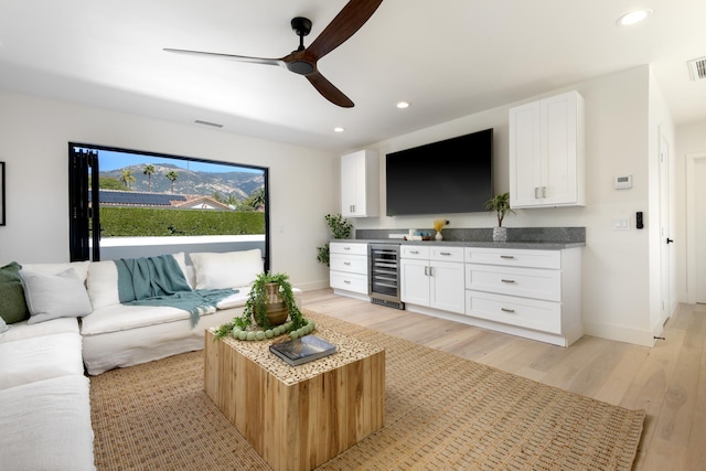 living area featuring wine cooler, recessed lighting, light wood-style floors, and baseboards