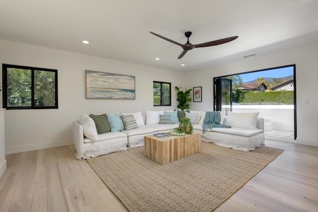 living area featuring recessed lighting, baseboards, a ceiling fan, and light wood finished floors