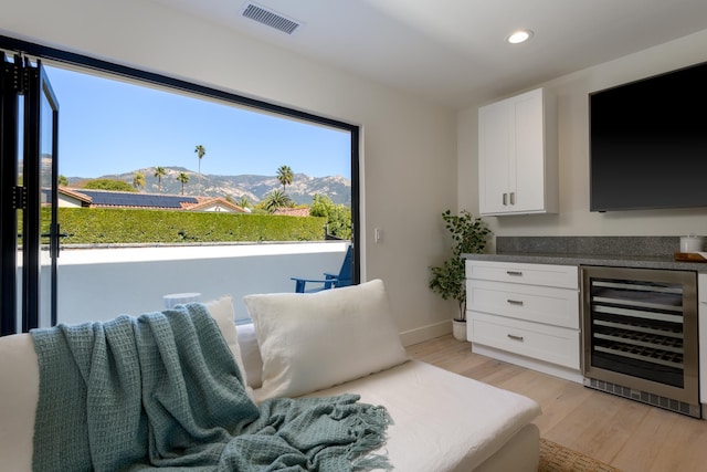 sitting room with visible vents, beverage cooler, light wood-style flooring, recessed lighting, and baseboards