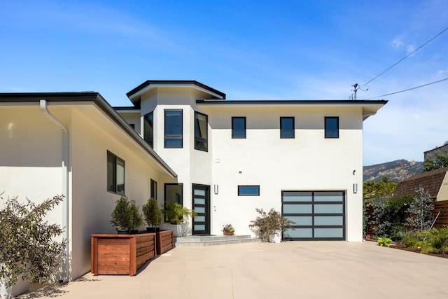 contemporary house with stucco siding, concrete driveway, and a garage