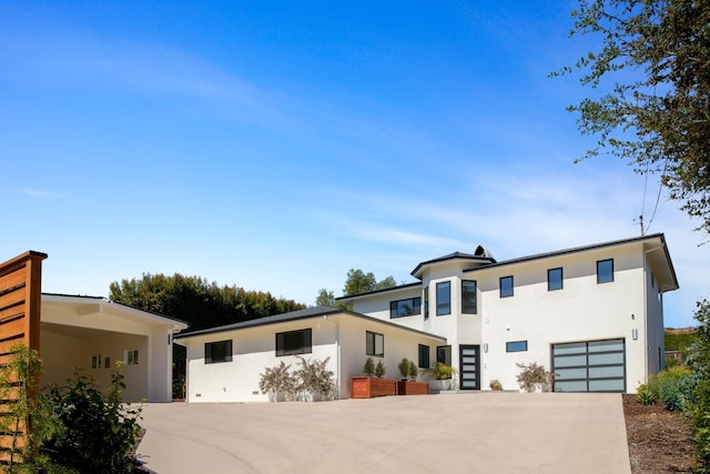 contemporary house with stucco siding, driveway, and a garage