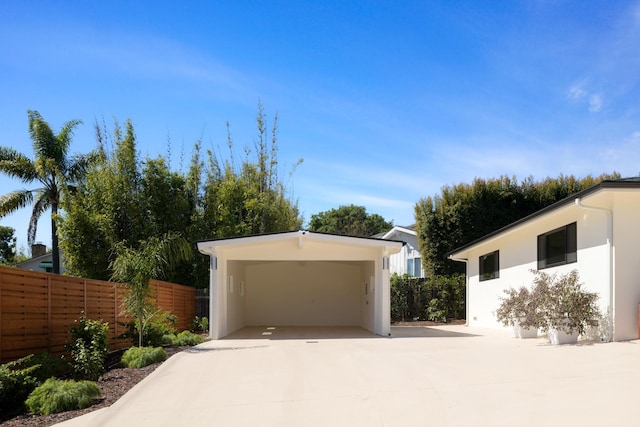 garage with fence and driveway