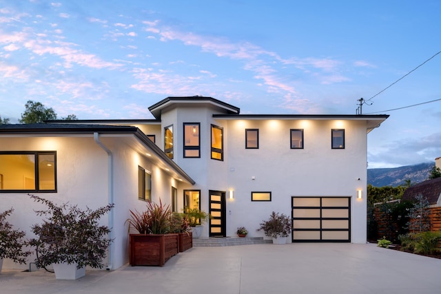 view of front facade with stucco siding, driveway, and a garage