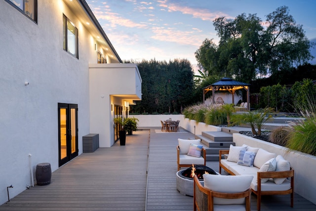 deck featuring an outdoor living space with a fire pit, a gazebo, and outdoor dining space