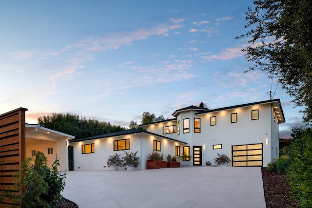 modern home with stucco siding, concrete driveway, and an attached garage