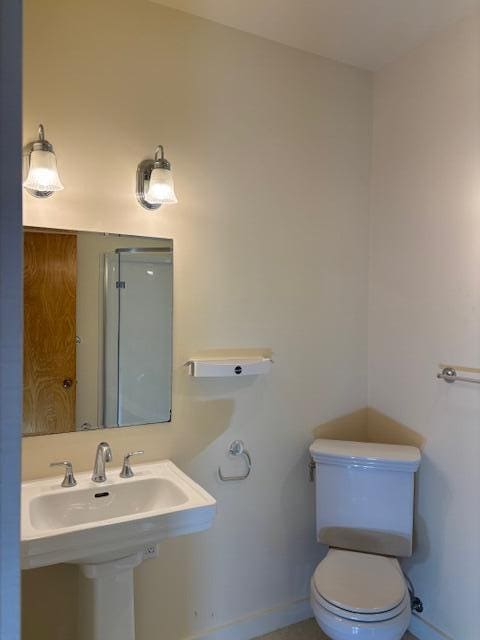 bathroom with a sink, toilet, and baseboards