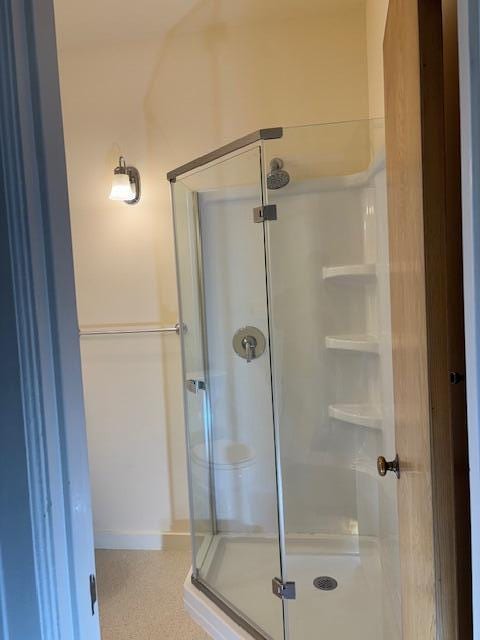 full bathroom featuring an enclosed shower and baseboards