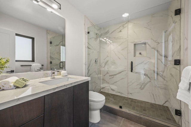 bathroom featuring vanity, a marble finish shower, and toilet