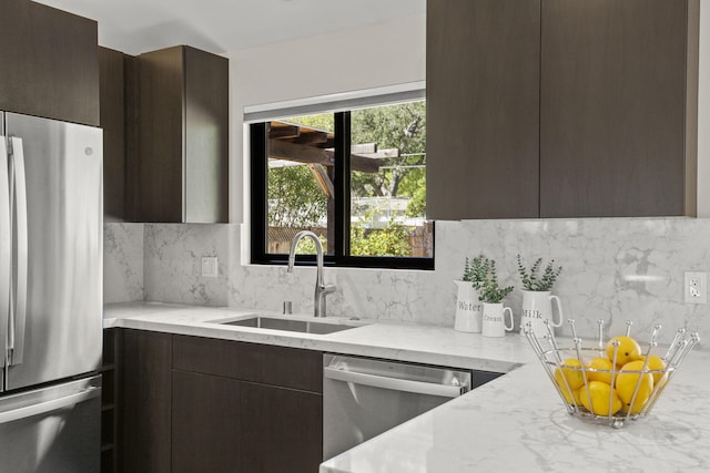 kitchen featuring stainless steel appliances, tasteful backsplash, a sink, dark brown cabinetry, and modern cabinets