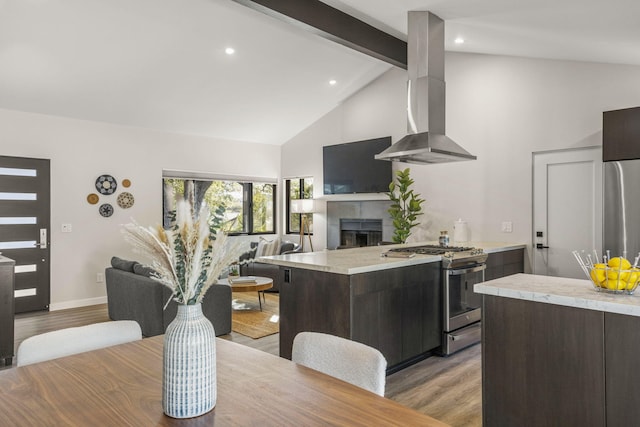 kitchen with appliances with stainless steel finishes, extractor fan, light countertops, and open floor plan