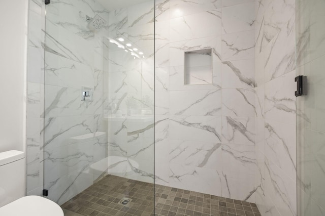 full bathroom with toilet and a marble finish shower