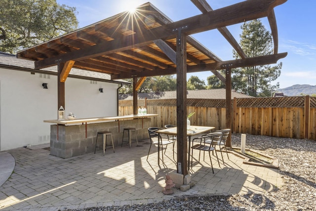 view of patio with outdoor dining area, fence, outdoor dry bar, and a pergola