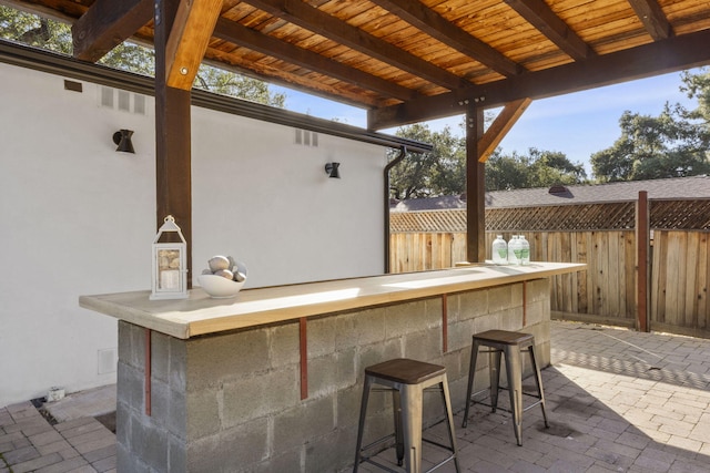 view of patio featuring visible vents, fence, and outdoor dry bar