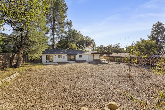 back of property featuring a fenced backyard and a patio